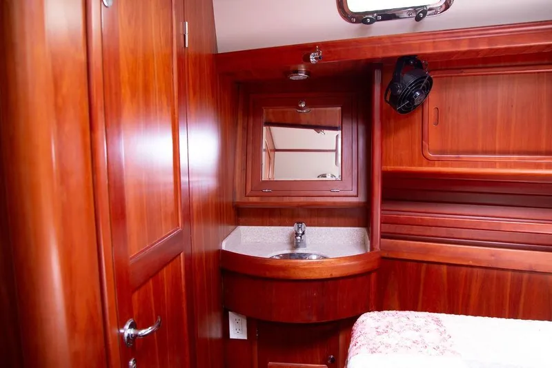 Slide: The Image of Luxurious wooden interior of 2015 Outbound 46 yacht cabin with sink and mirror. - 53