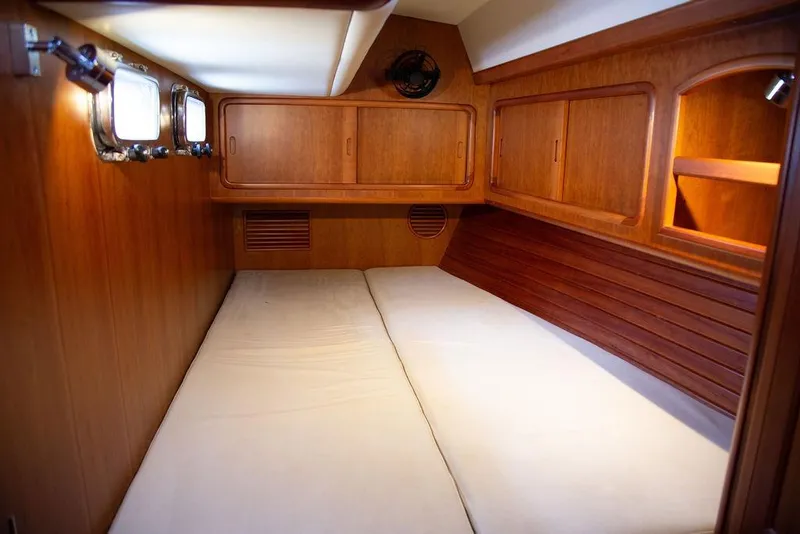 Slide: The Image of Cozy cabin interior of 2015 Outbound 46 yacht with wooden finish and bedding. - 55