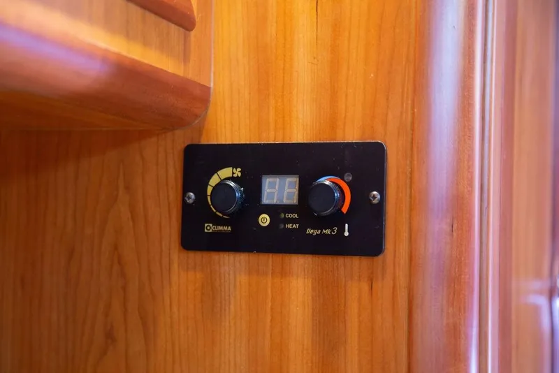 Slide: The Image of Thermostat control panel on 2015 Outbound 46 yacht, mounted on wooden interior. - 56