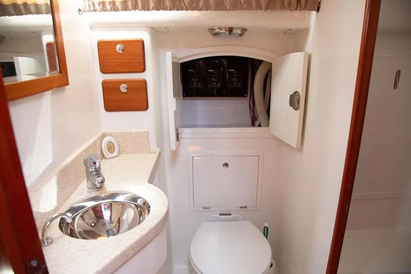 Slide: The Image of Compact bathroom in 2015 Outbound 46 yacht with sink, toilet, and storage cabinets. - 58