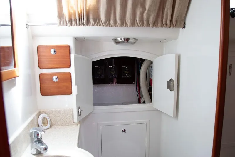 Slide: The Image of Interior of 2015 Outbound 46 yacht showing storage cabinets and plumbing access. - 59