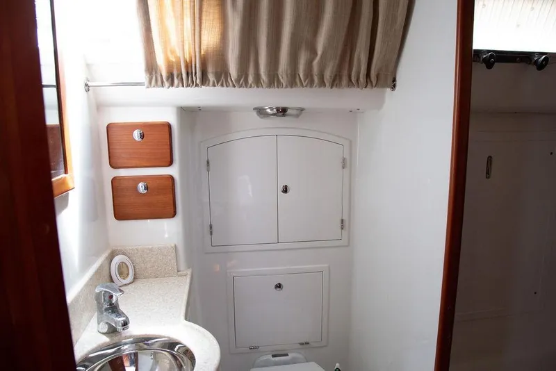 Slide: The Image of Compact bathroom interior of 2015 Outbound 46 yacht with sink and storage cabinets. - 61
