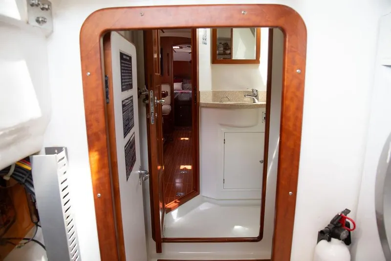 Slide: The Image of Interior view of 2015 Outbound 46 yacht, featuring a compact bathroom and wooden accents. - 64