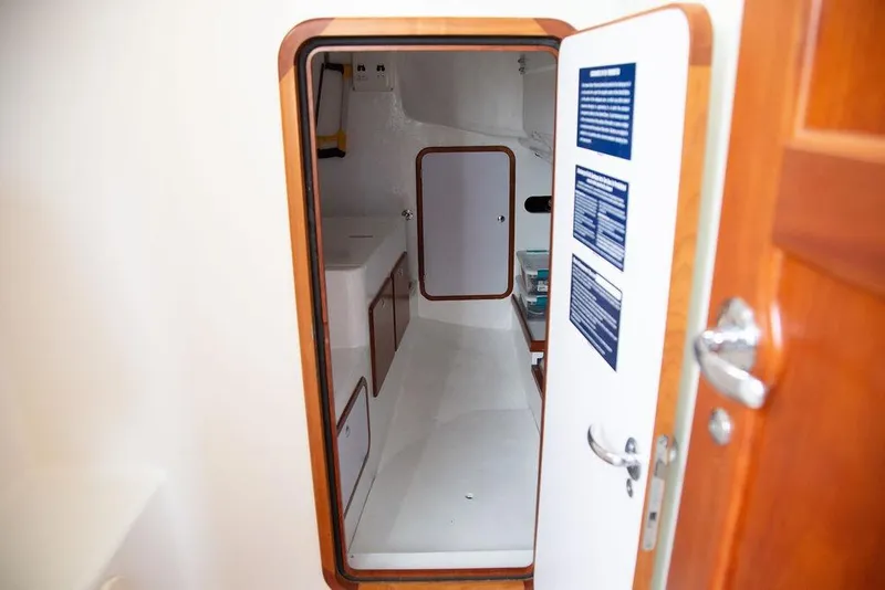 Slide: The Image of Interior view of 2015 Outbound 46 sailboat cabin with wooden door and storage compartments. - 65
