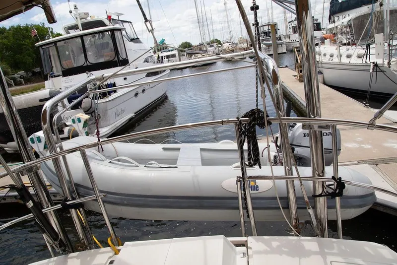 Slide: The Image of Docked Outbound 46 sailboat with inflatable dinghy and Honda motor, 2015 model. - 95