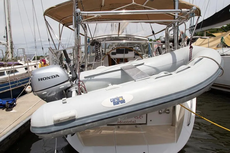 Slide: The Image of Sailboat Outbound 46 (2015) with dinghy and Honda outboard motor at marina. - 99