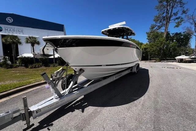 Slide: The Image of 2020 Blackfin 332 CC boat on trailer, parked outdoors near marine facility. - 2