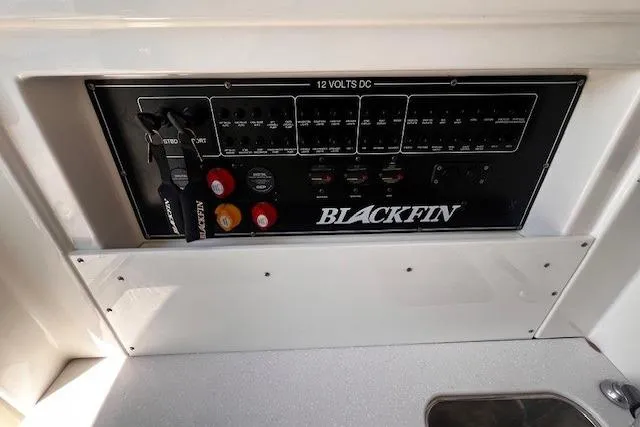 Slide: The Image of Control panel of 2020 Blackfin 332 CC boat, featuring 12 volts DC switches and branding. - 22