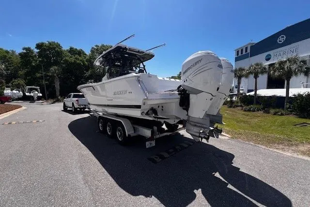 Slide: The Image of 2020 Blackfin 332 CC boat on trailer, parked outdoors under clear blue sky. - 3