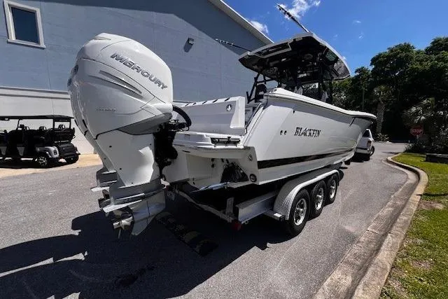 Slide: The Image of 2020 Blackfin 332 CC boat with Mercury engines on a trailer, parked outdoors. - 5