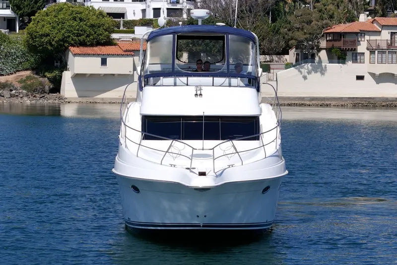 Slide: The Image of 2004 Silverton 39 MY Diesel yacht on calm water near coastal homes. - 7
