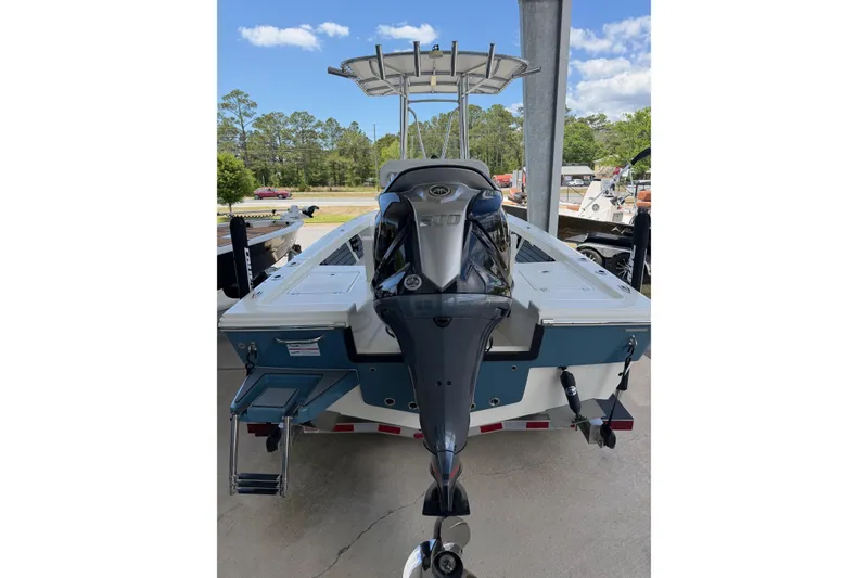 Slide: The Image of 2025 Pathfinder 2200 TRS boat with outboard motor, parked outdoors. - 2