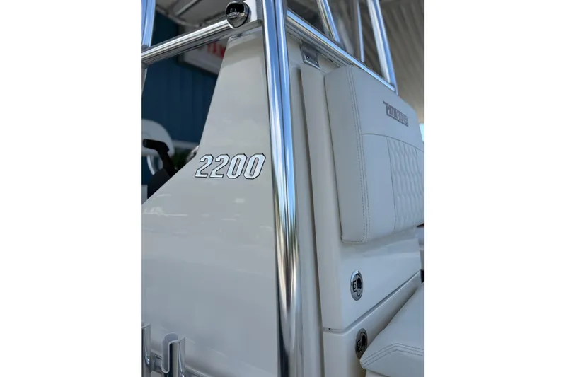Slide: The Image of 2025 Pathfinder 2200 TRS boat interior with chrome details and white seating. - 4