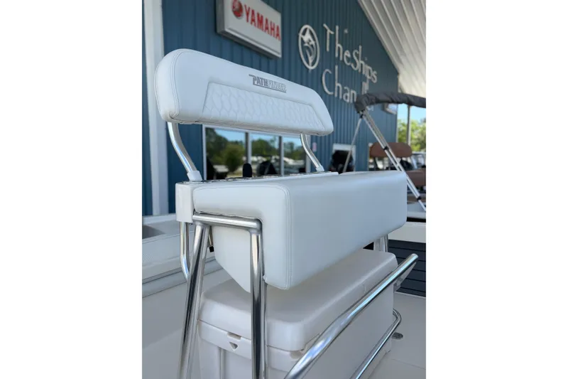 Slide: The Image of 2025 Pathfinder 2200 TRS boat seat with white upholstery and chrome accents at a dealership. - 6