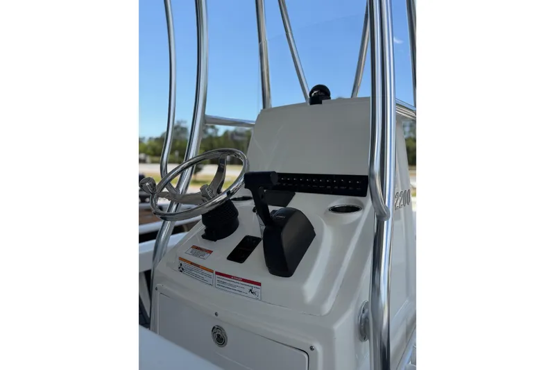 Slide: The Image of Steering console of 2025 Pathfinder 2200 TRS boat with chrome details and controls. - 7
