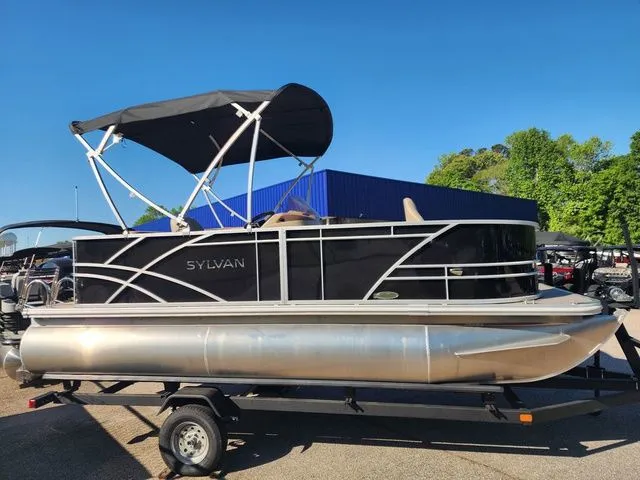 The Image of Sylvan 818 FISH 2025 pontoon boat with black canopy on trailer. - 1