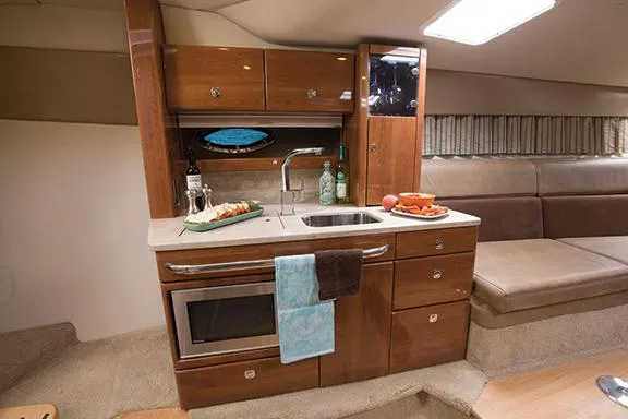 Slide: The Image of Manufacturer Provided Image: 2015 Formula 370 Super Sport yacht interior kitchen with sink, microwave, and seating area. - 20