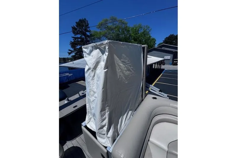 Slide: The Image of 2015 Bennington 2275 GS boat with covered console, parked outdoors under clear blue sky. - 10