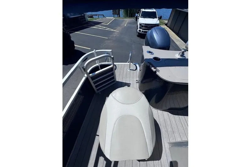 Slide: The Image of 2015 Bennington 2275 GS pontoon boat interior with seating and motor view. - 11
