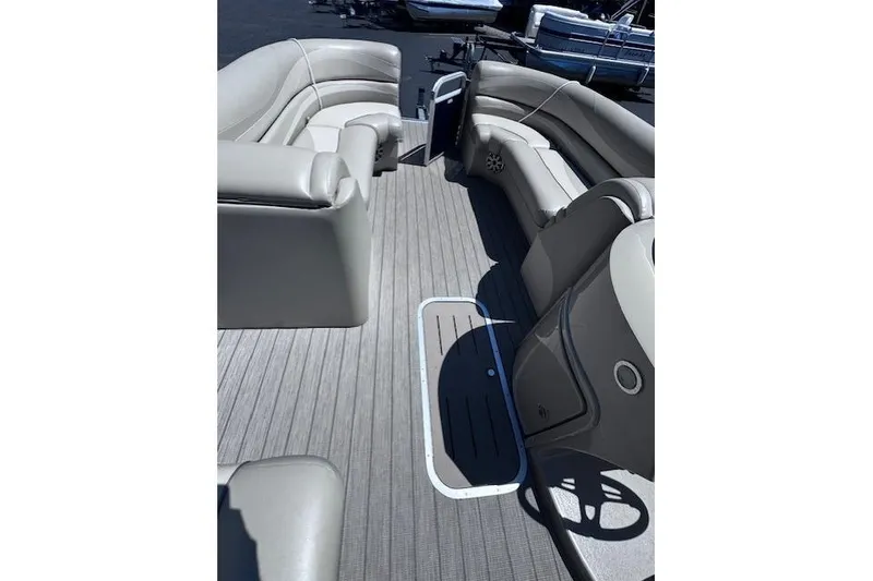 Slide: The Image of 2015 Bennington 2275 GS pontoon boat interior with beige seating and gray flooring. - 12