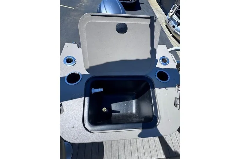 Slide: The Image of Open storage compartment on a 2015 Bennington 2275 GS boat, featuring cup holders. - 9