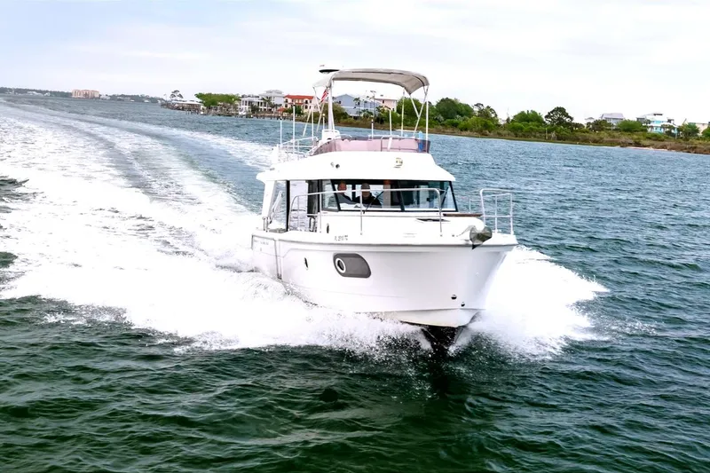 Slide: The Image of 2018 Beneteau Swift Trawler 30 cruising on open water near shoreline. - 1