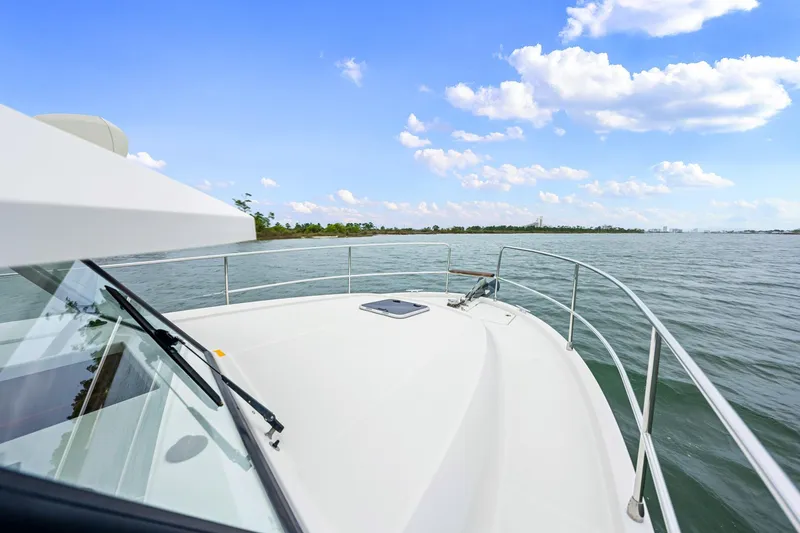 Slide: The Image of 2018 Beneteau Swift Trawler 30 cruising on open water under a clear blue sky. - 11