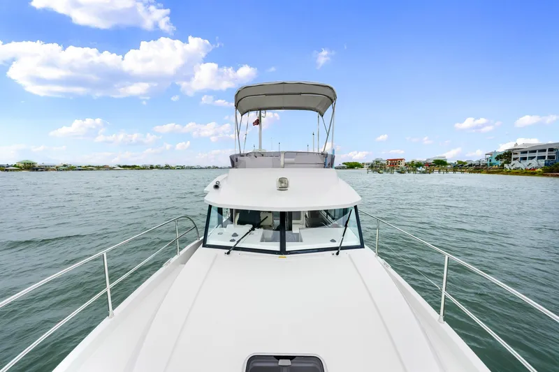 Slide: The Image of 2018 Beneteau Swift Trawler 30 cruising on a calm, scenic waterway. - 12