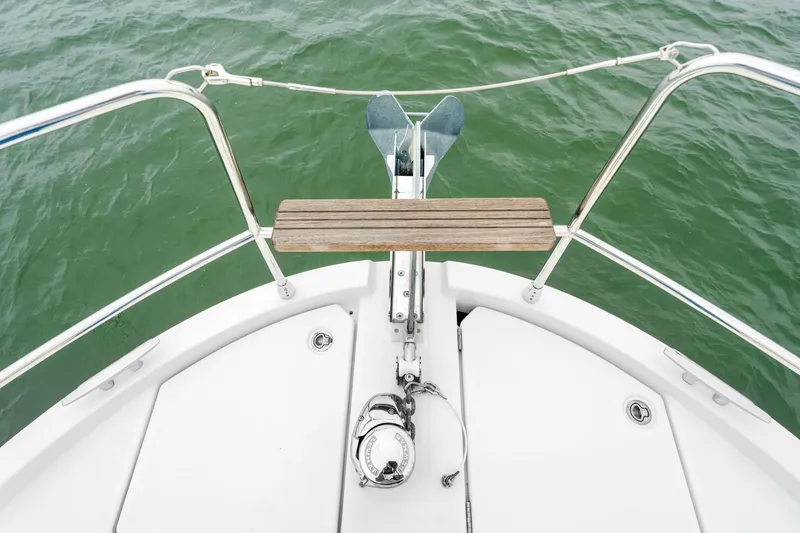 Slide: The Image of Bow of 2018 Beneteau Swift Trawler 30 with anchor and railing over green water. - 13