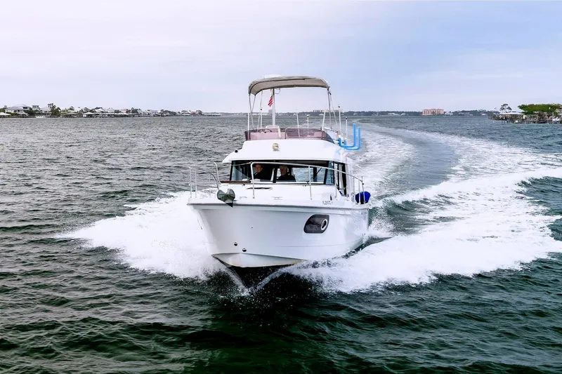 Slide: The Image of 2018 Beneteau Swift Trawler 30 cruising on open water, creating a wake. - 2