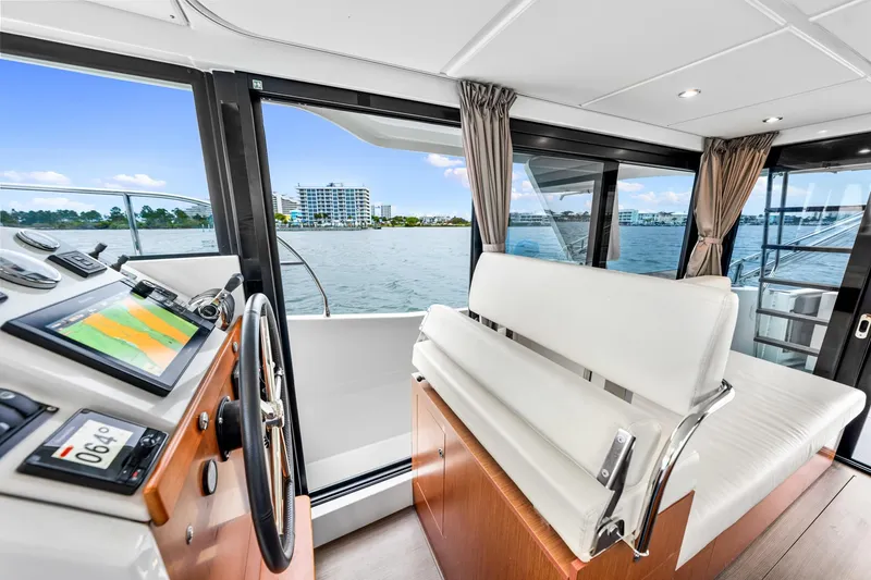 Slide: The Image of Interior view of 2018 Beneteau Swift Trawler 30 helm with panoramic windows and modern controls. - 24