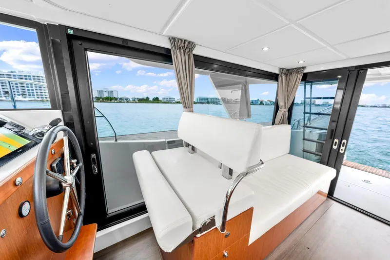 Slide: The Image of Interior view of 2018 Beneteau Swift Trawler 30, featuring helm and seating area with ocean view. - 25