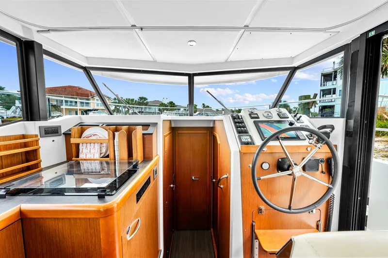 Slide: The Image of Interior of 2018 Beneteau Swift Trawler 30, featuring helm and galley area. - 26