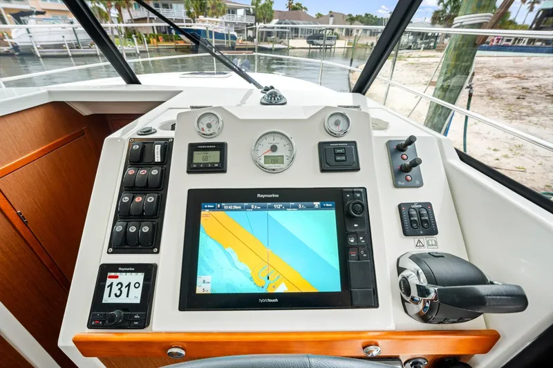 Slide: The Image of 2018 Beneteau Swift Trawler 30 helm with navigation display and control panel. - 27