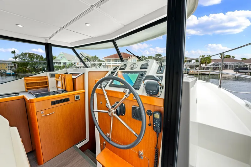 Slide: The Image of 2018 Beneteau Swift Trawler 30 helm with modern controls and waterfront view. - 28