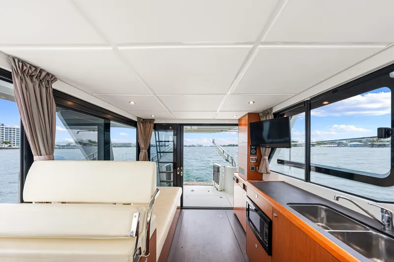Slide: The Image of Interior of 2018 Beneteau Swift Trawler 30 with modern kitchen and scenic water view. - 30
