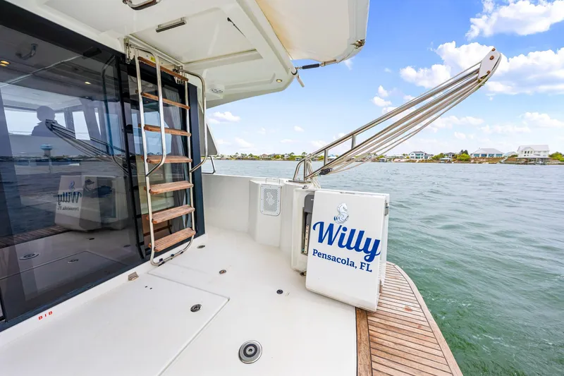 Slide: The Image of 2018 Beneteau Swift Trawler 30 docked, featuring a ladder and "Willy" signage, Pensacola, FL. - 34