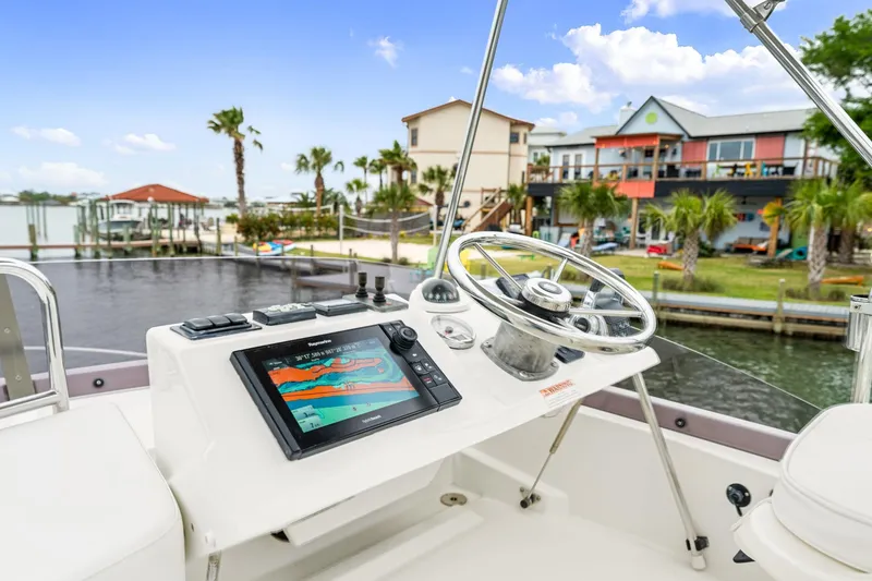 Slide: The Image of 2018 Beneteau Swift Trawler 30 helm with navigation display, dockside view. - 36