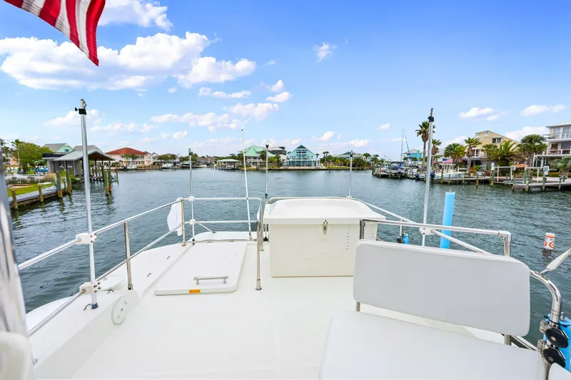 Slide: The Image of 2018 Beneteau Swift Trawler 30 on calm waters, with scenic waterfront view. - 37