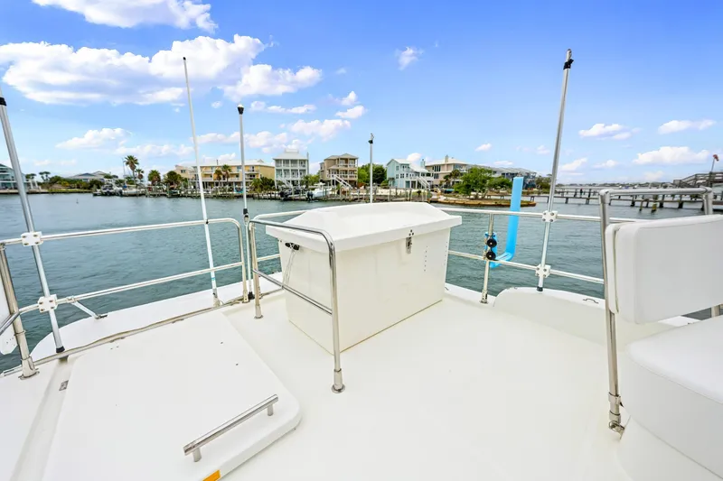 Slide: The Image of 2018 Beneteau Swift Trawler 30 deck overlooking waterfront homes and clear blue sky. - 38