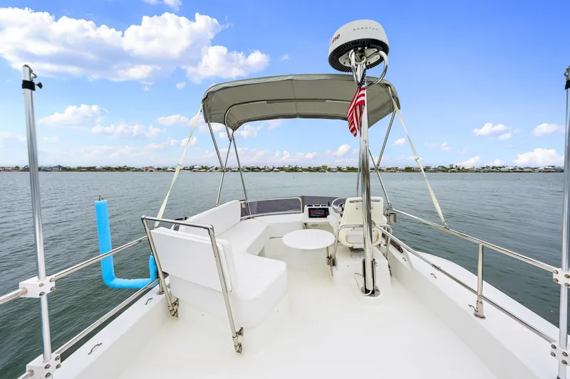 Slide: The Image of Flybridge of 2018 Beneteau Swift Trawler 30 with seating, table, and canopy on calm water. - 40