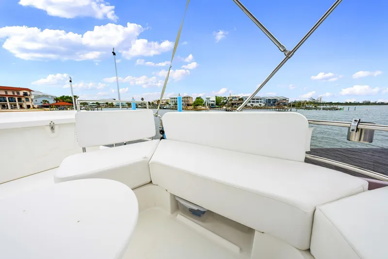 Slide: The Image of 2018 Beneteau Swift Trawler 30 with white seating, docked by waterfront homes under blue sky. - 43
