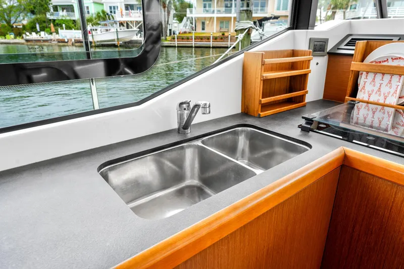 Slide: The Image of 2018 Beneteau Swift Trawler 30 kitchen with dual sink and wooden cabinetry. - 47