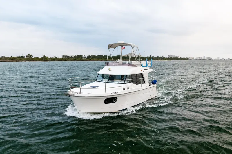 Slide: The Image of 2018 Beneteau Swift Trawler 30 cruising on open water, showcasing sleek design and performance. - 5