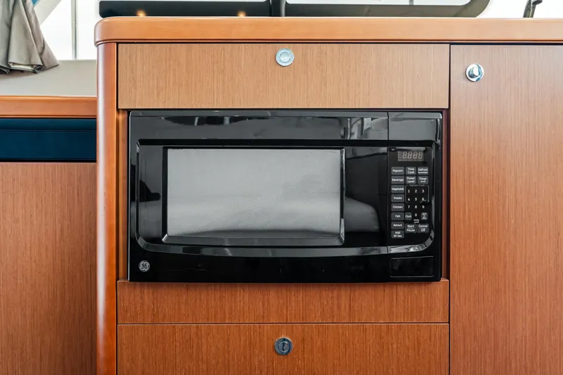 Slide: The Image of Microwave in 2018 Beneteau Swift Trawler 30, set in wooden cabinetry. - 51