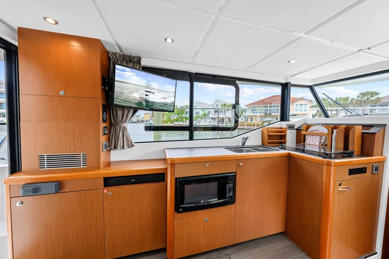 Slide: The Image of Interior of 2018 Beneteau Swift Trawler 30 with modern kitchen and waterfront view. - 57