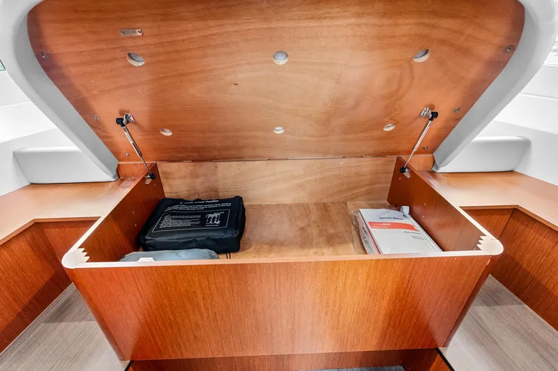 Slide: The Image of 2018 Beneteau Swift Trawler 30 interior storage compartment with manuals and equipment. - 63