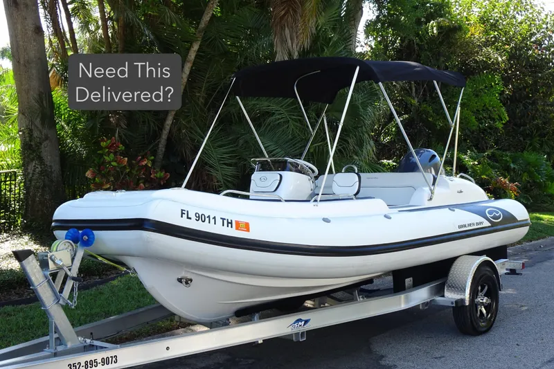 Slide: The Image of 2022 Walker Bay Generation 525 boat on trailer, ready for delivery, surrounded by lush greenery. - 1