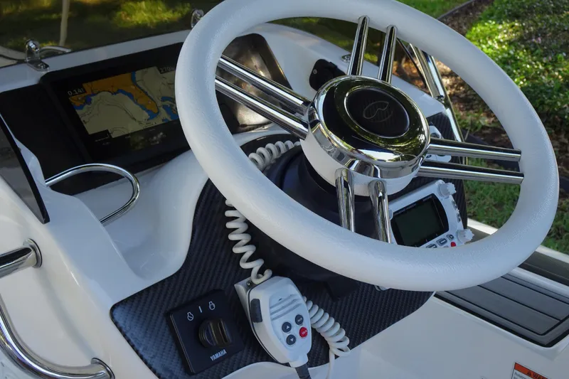 Slide: The Image of 2022 Walker Bay Generation 525 boat steering wheel with navigation controls and display. - 22