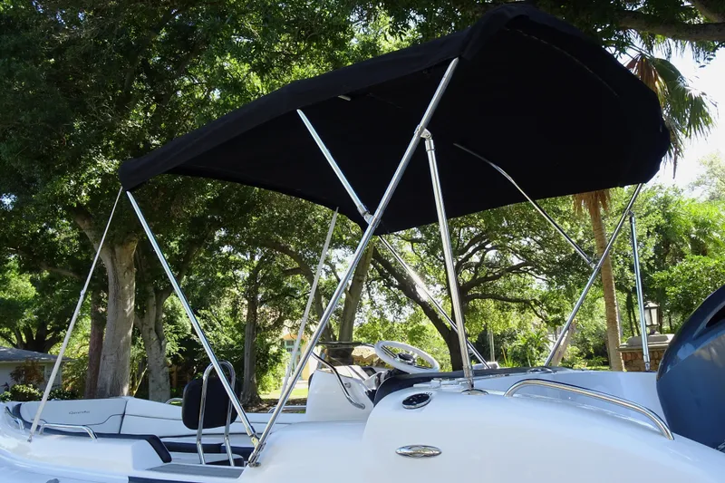 Slide: The Image of 2022 Walker Bay Generation 525 boat with canopy, surrounded by lush greenery. - 6